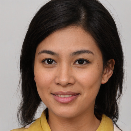 Joyful asian young-adult female with medium  brown hair and brown eyes