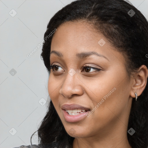 Joyful black young-adult female with long  brown hair and brown eyes