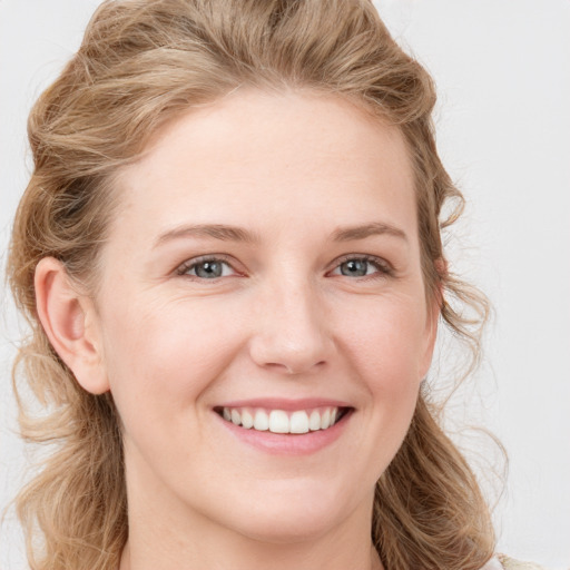 Joyful white young-adult female with long  brown hair and blue eyes