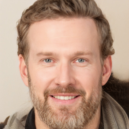 Joyful white adult male with short  brown hair and grey eyes