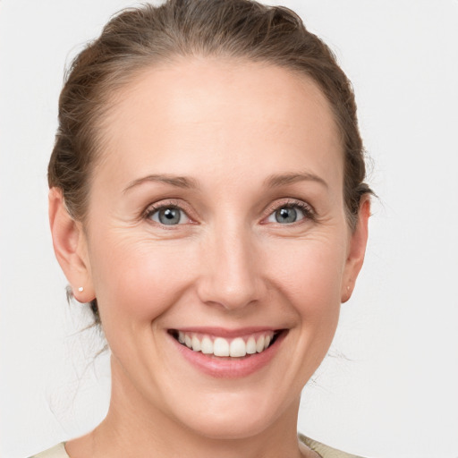 Joyful white young-adult female with medium  brown hair and grey eyes