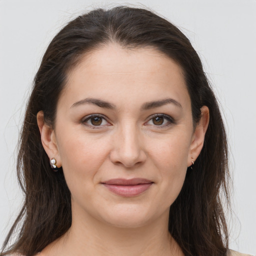 Joyful white young-adult female with long  brown hair and brown eyes