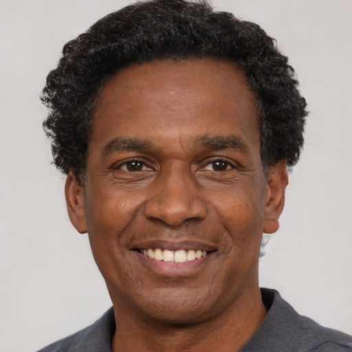 Joyful black adult male with short  black hair and brown eyes