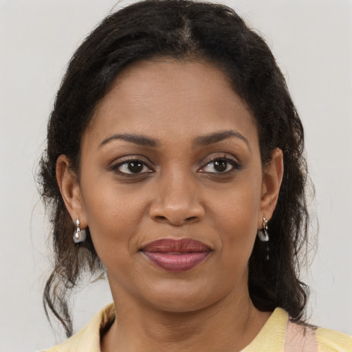 Joyful black adult female with medium  brown hair and brown eyes