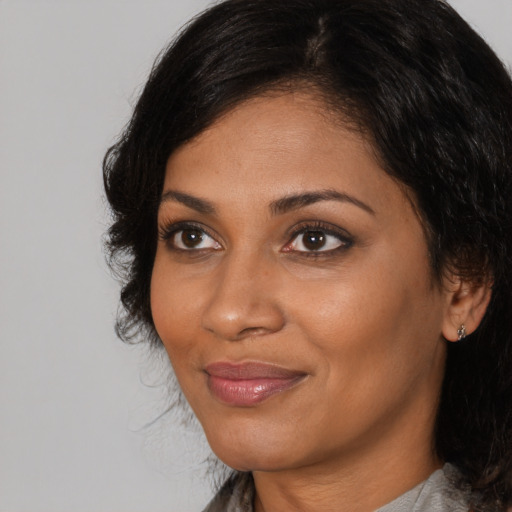 Joyful black adult female with medium  brown hair and brown eyes