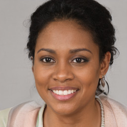 Joyful black young-adult female with long  brown hair and brown eyes