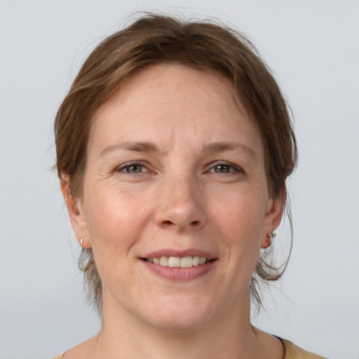 Joyful white adult female with medium  brown hair and grey eyes