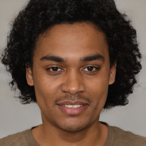 Joyful black young-adult male with short  brown hair and brown eyes