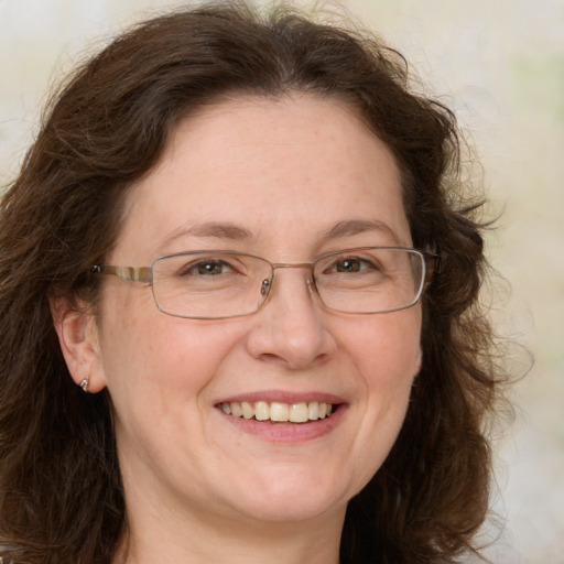 Joyful white adult female with medium  brown hair and green eyes