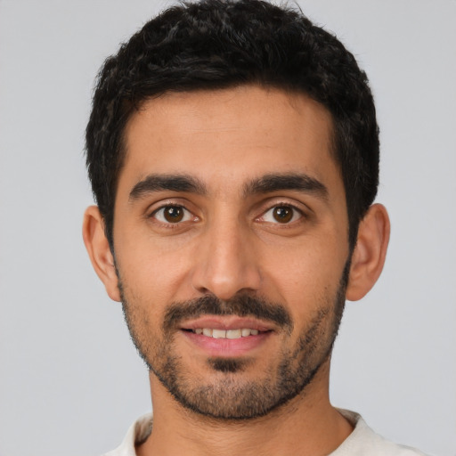 Joyful latino young-adult male with short  black hair and brown eyes