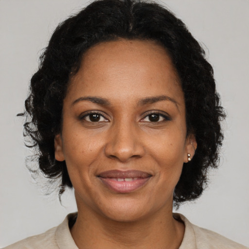 Joyful black adult female with medium  brown hair and brown eyes