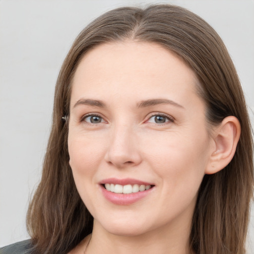 Joyful white young-adult female with long  brown hair and grey eyes