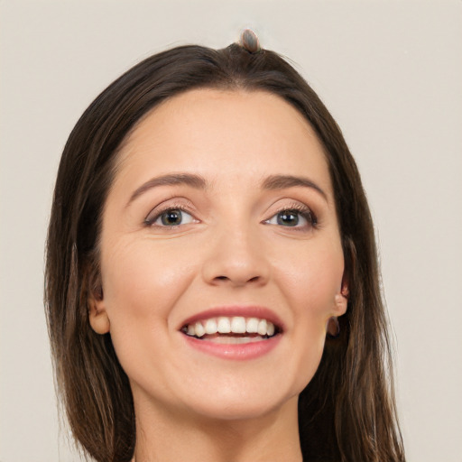 Joyful white young-adult female with long  brown hair and grey eyes