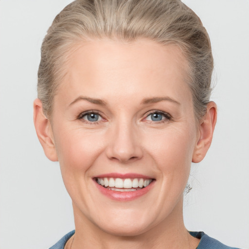 Joyful white adult female with medium  brown hair and blue eyes