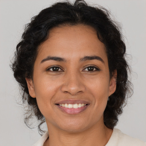 Joyful latino young-adult female with medium  brown hair and brown eyes