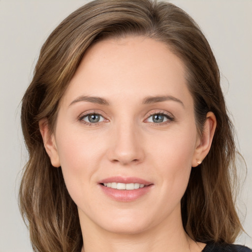 Joyful white young-adult female with medium  brown hair and grey eyes