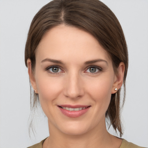 Joyful white young-adult female with medium  brown hair and grey eyes