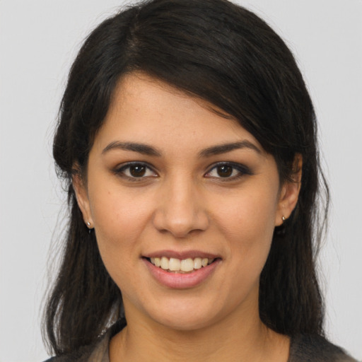 Joyful latino young-adult female with long  brown hair and brown eyes