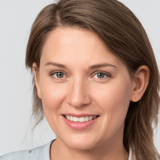 Joyful white young-adult female with medium  brown hair and grey eyes