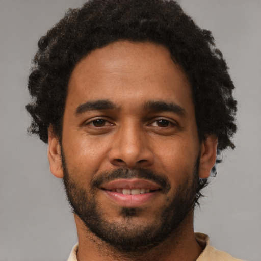 Joyful black young-adult male with short  brown hair and brown eyes