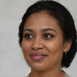 Joyful black adult female with medium  brown hair and brown eyes