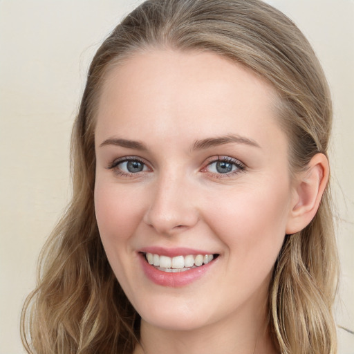 Joyful white young-adult female with long  brown hair and blue eyes