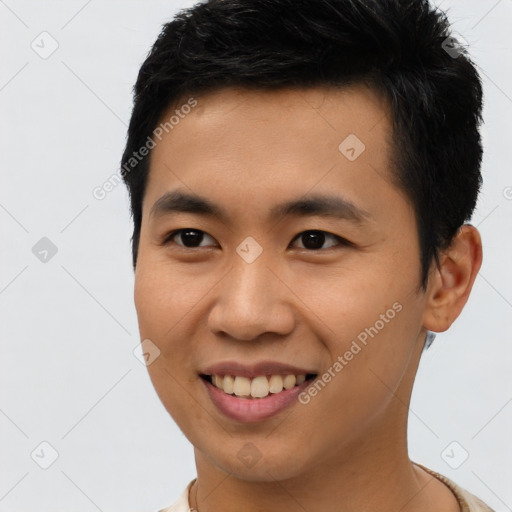 Joyful asian young-adult male with short  black hair and brown eyes