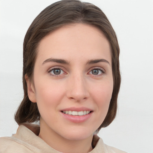 Joyful white young-adult female with medium  brown hair and grey eyes