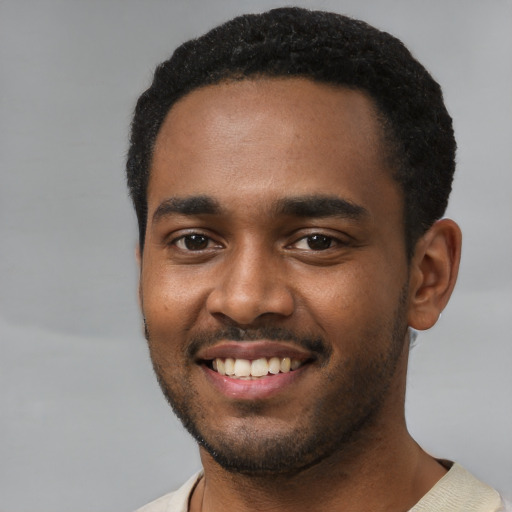 Joyful black young-adult male with short  black hair and brown eyes
