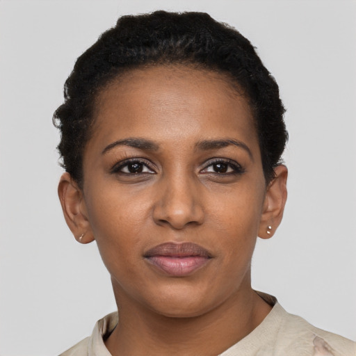 Joyful black young-adult female with short  black hair and brown eyes