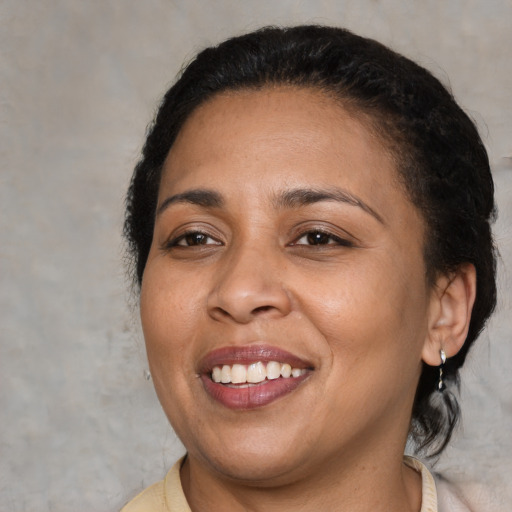 Joyful latino adult female with medium  brown hair and brown eyes