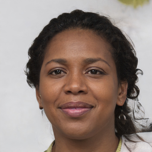 Joyful black adult female with medium  brown hair and brown eyes