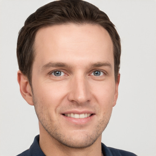 Joyful white young-adult male with short  brown hair and grey eyes