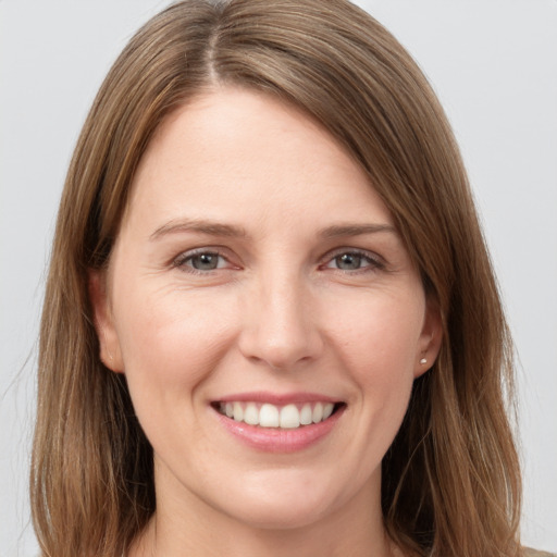 Joyful white young-adult female with long  brown hair and grey eyes