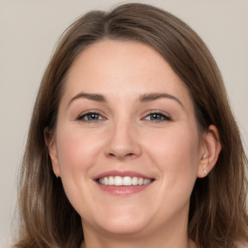 Joyful white young-adult female with long  brown hair and grey eyes