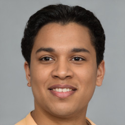 Joyful latino young-adult male with short  brown hair and brown eyes