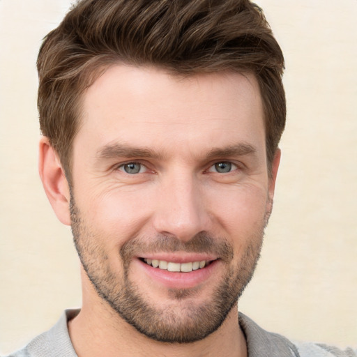 Joyful white young-adult male with short  brown hair and grey eyes