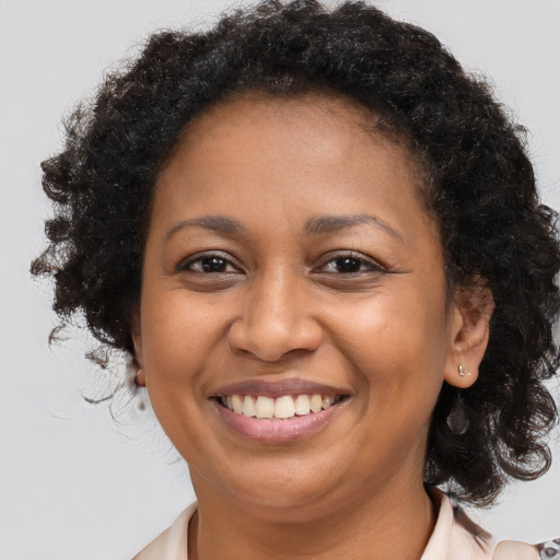 Joyful black adult female with long  brown hair and brown eyes