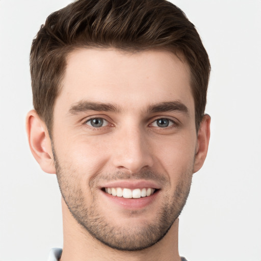 Joyful white young-adult male with short  brown hair and grey eyes