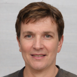 Joyful white adult male with short  brown hair and grey eyes