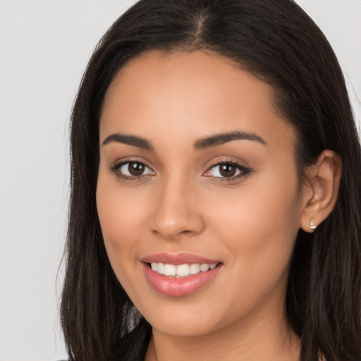 Joyful latino young-adult female with long  brown hair and brown eyes