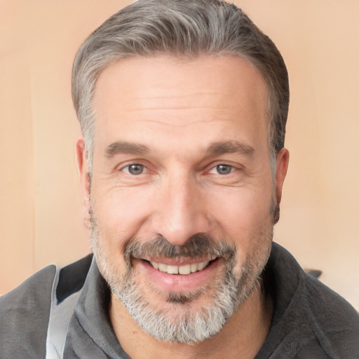 Joyful white adult male with short  gray hair and brown eyes