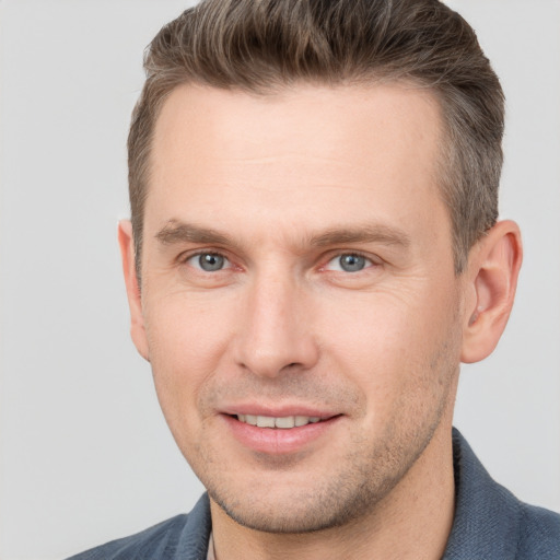 Joyful white adult male with short  brown hair and grey eyes