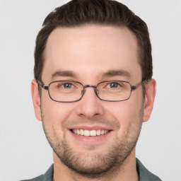 Joyful white young-adult male with short  brown hair and grey eyes