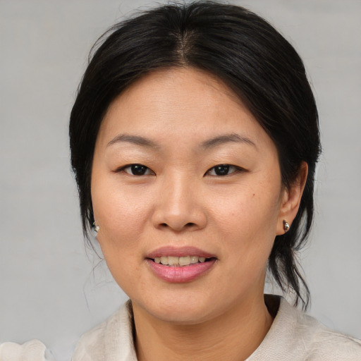 Joyful asian young-adult female with medium  brown hair and brown eyes