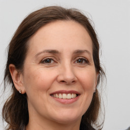 Joyful white adult female with long  brown hair and brown eyes