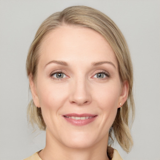 Joyful white adult female with medium  brown hair and blue eyes