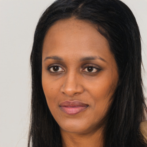 Joyful black young-adult female with long  black hair and brown eyes