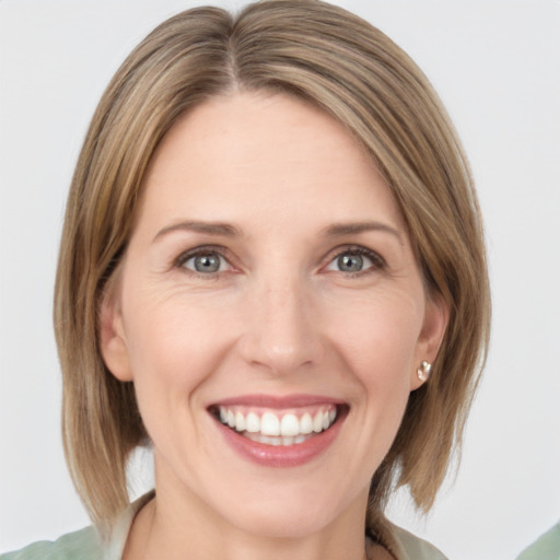 Joyful white young-adult female with medium  brown hair and grey eyes