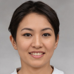 Joyful asian young-adult female with short  brown hair and brown eyes